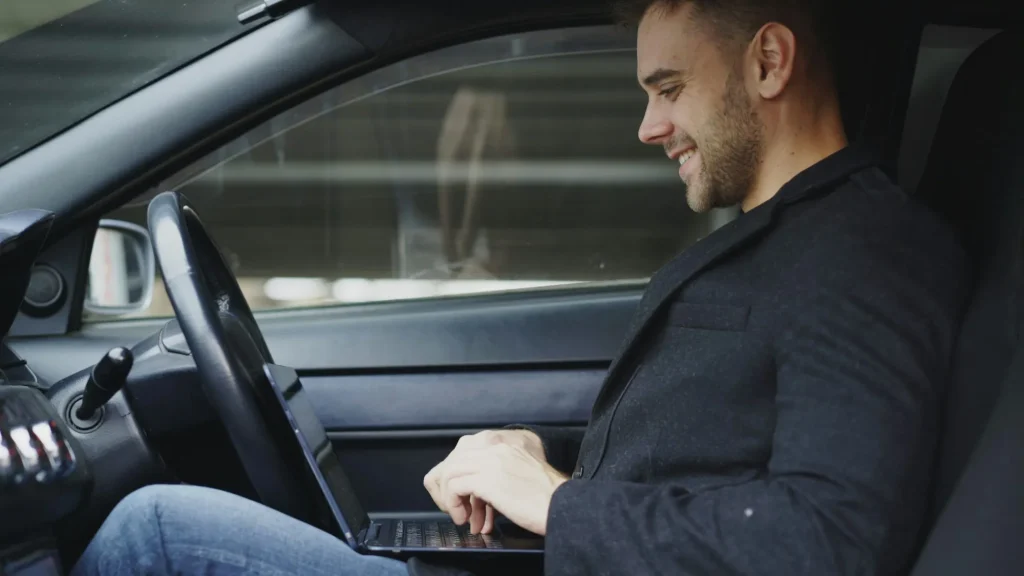 Executive working on a laptop in a chauffeured corporate car